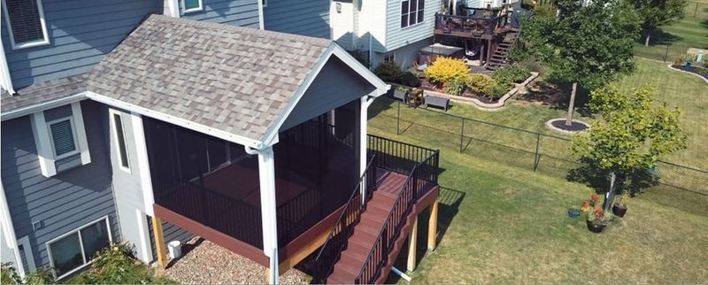An aerial view of a house with a screened in porch and a deck.