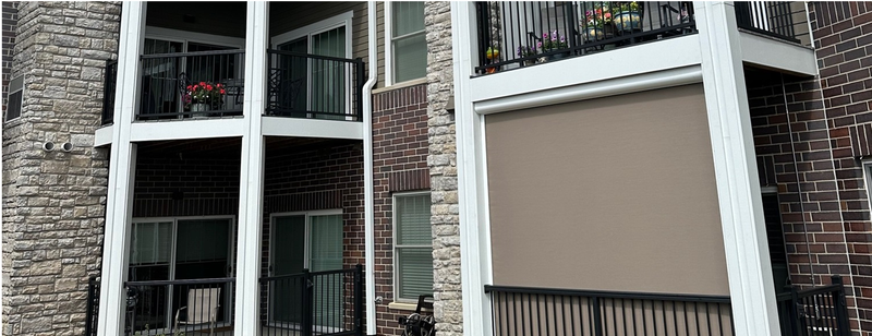 A brick building with a balcony and a screened in porch.