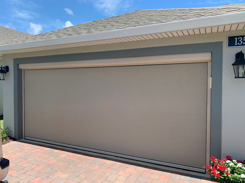 A large garage door is sitting on the side of a house.