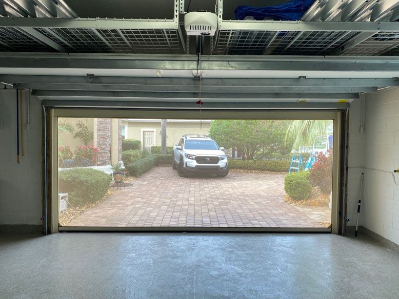 A car is parked in a garage with the door open.