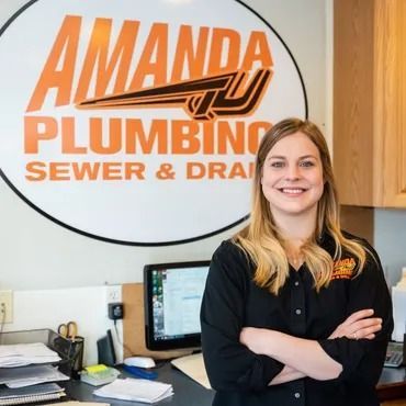 Woman with crossed arms smiles, standing in front of