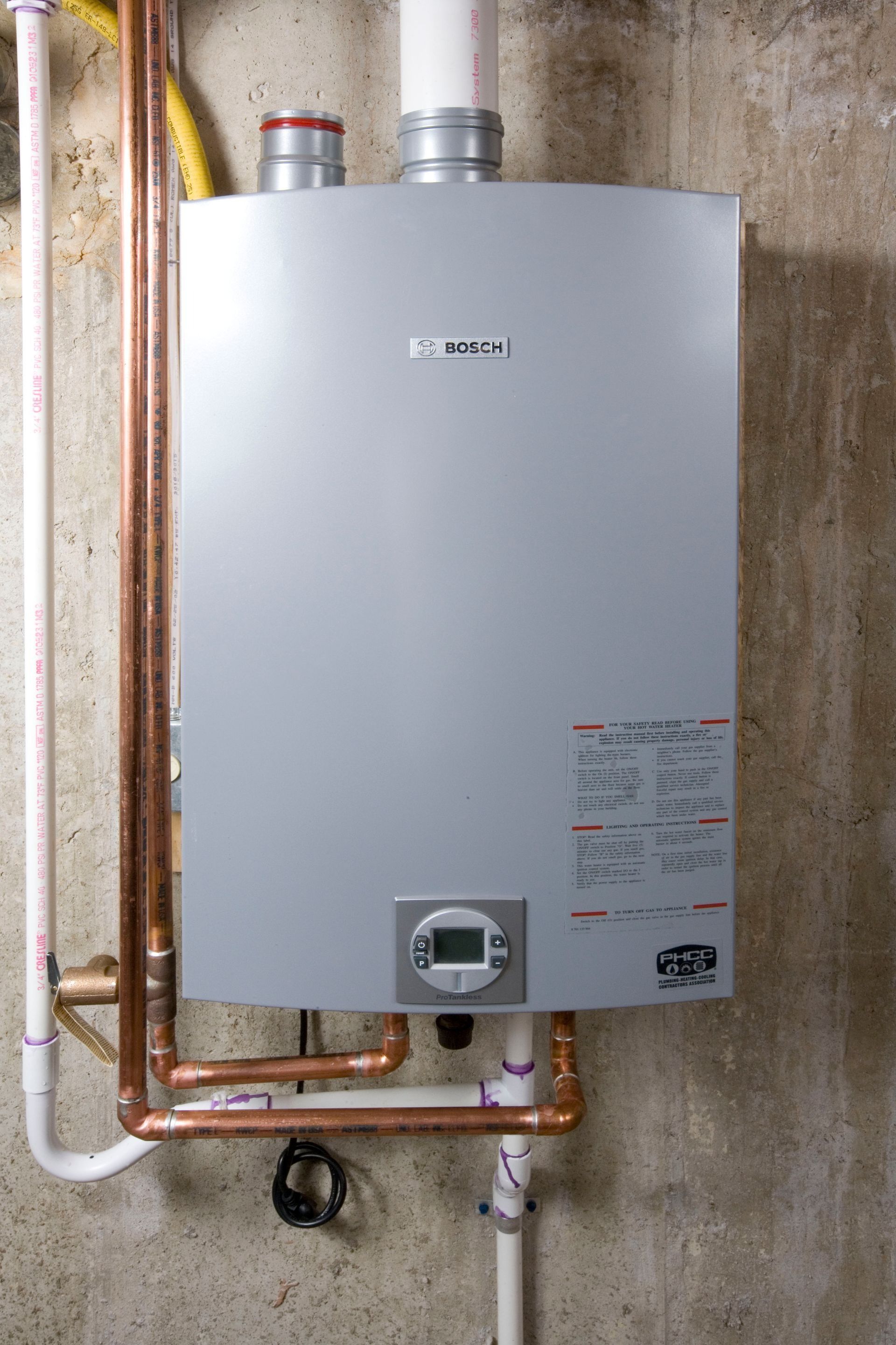 A wall-mounted Bosch gas-fired condensing boiler. Copper pipes and white PVC tubes are connected to it.