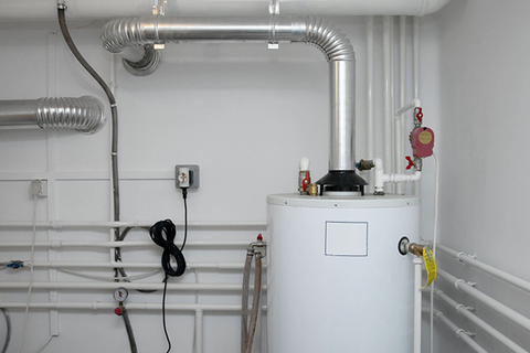 Water heater in a utility room, with pipes, vents, and electrical components.