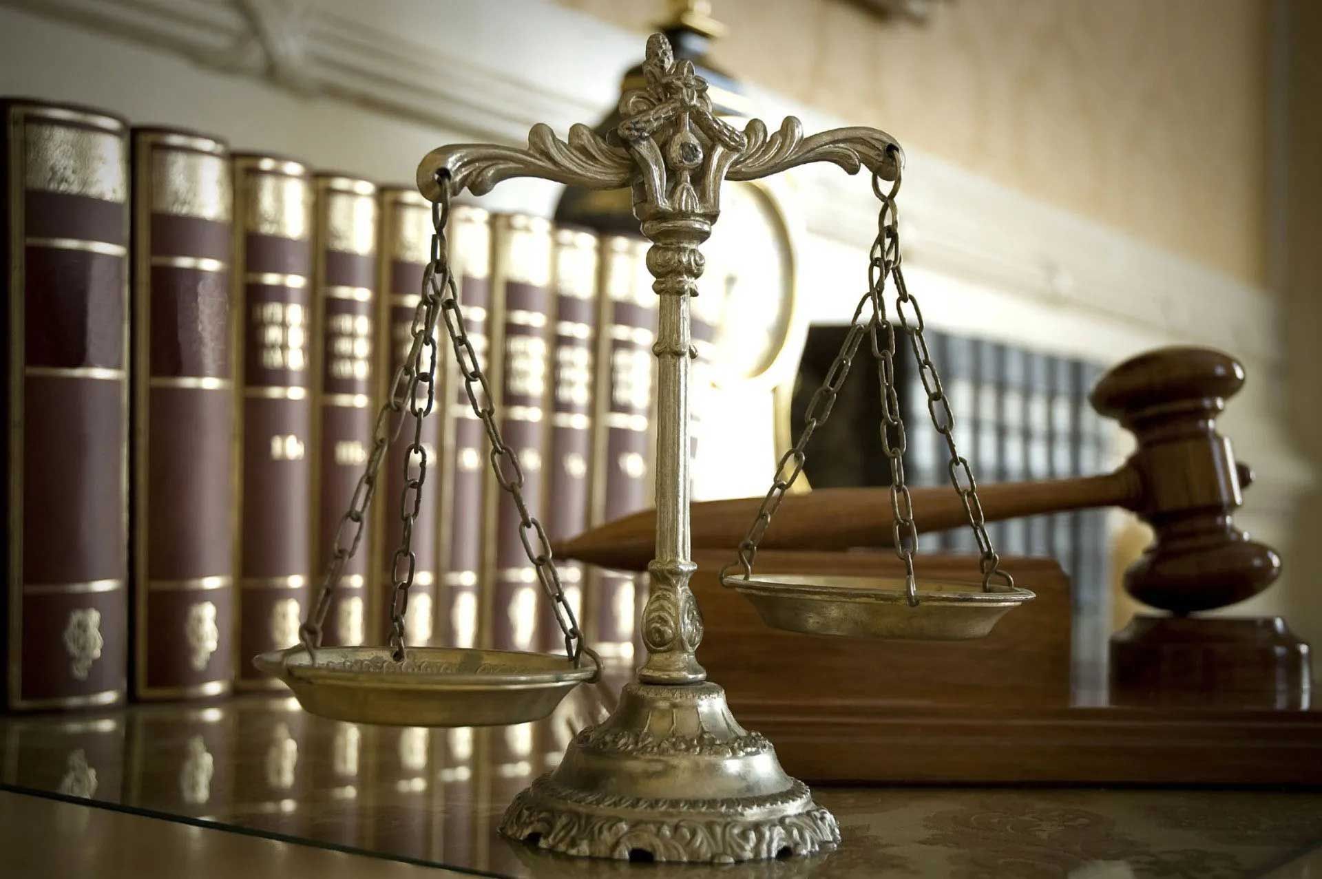 Scales of justice with books and gavel in the background, representing law and order.