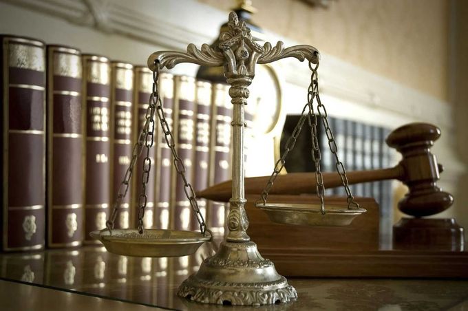 Scales of justice with books and gavel in the background, representing law and order.
