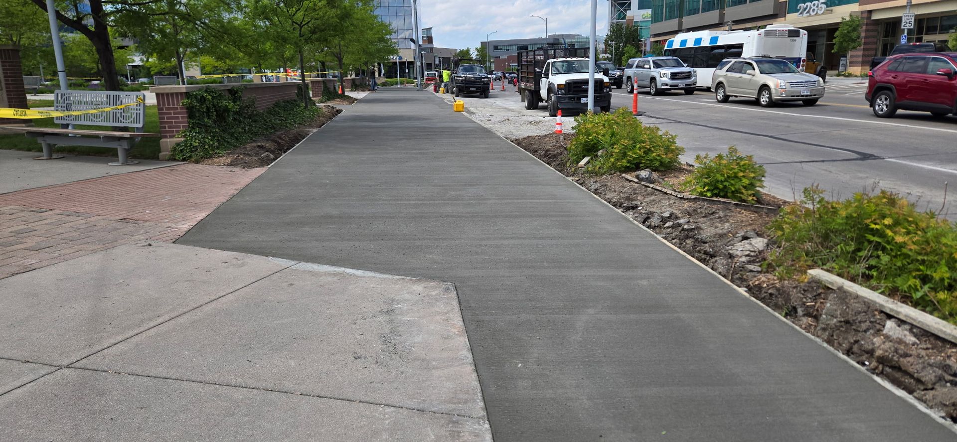 A concrete sidewalk is being built on the side of a city street.