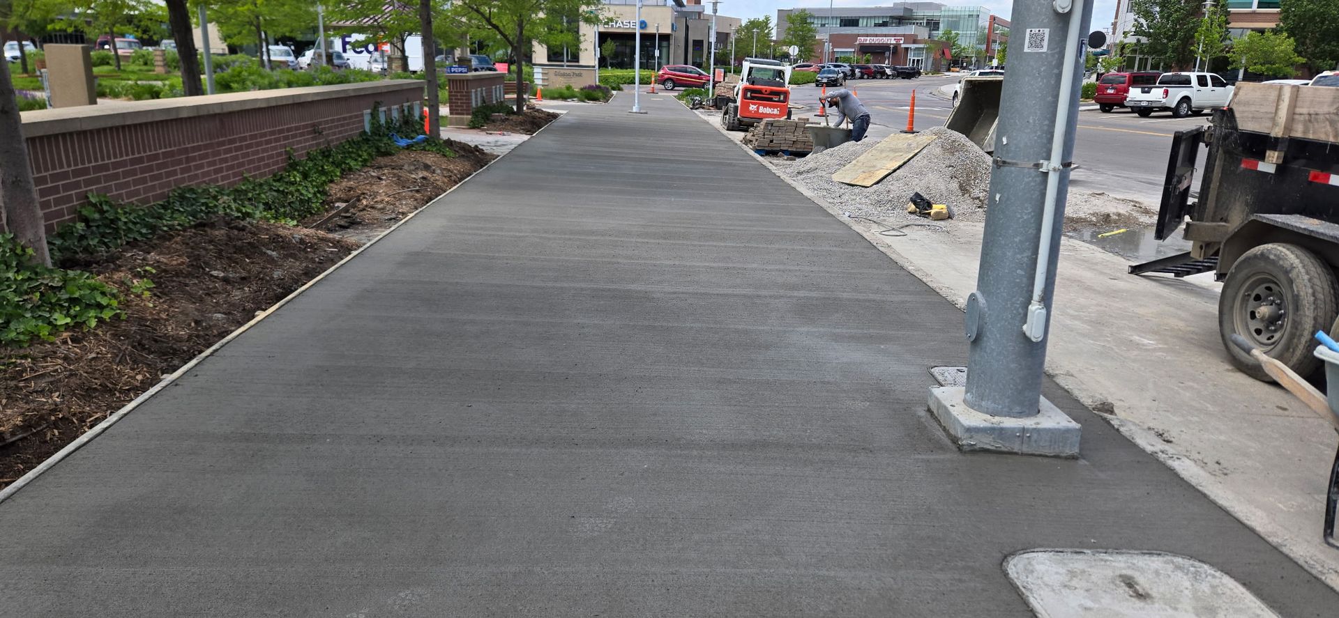 A concrete walkway is being built on the side of the road.