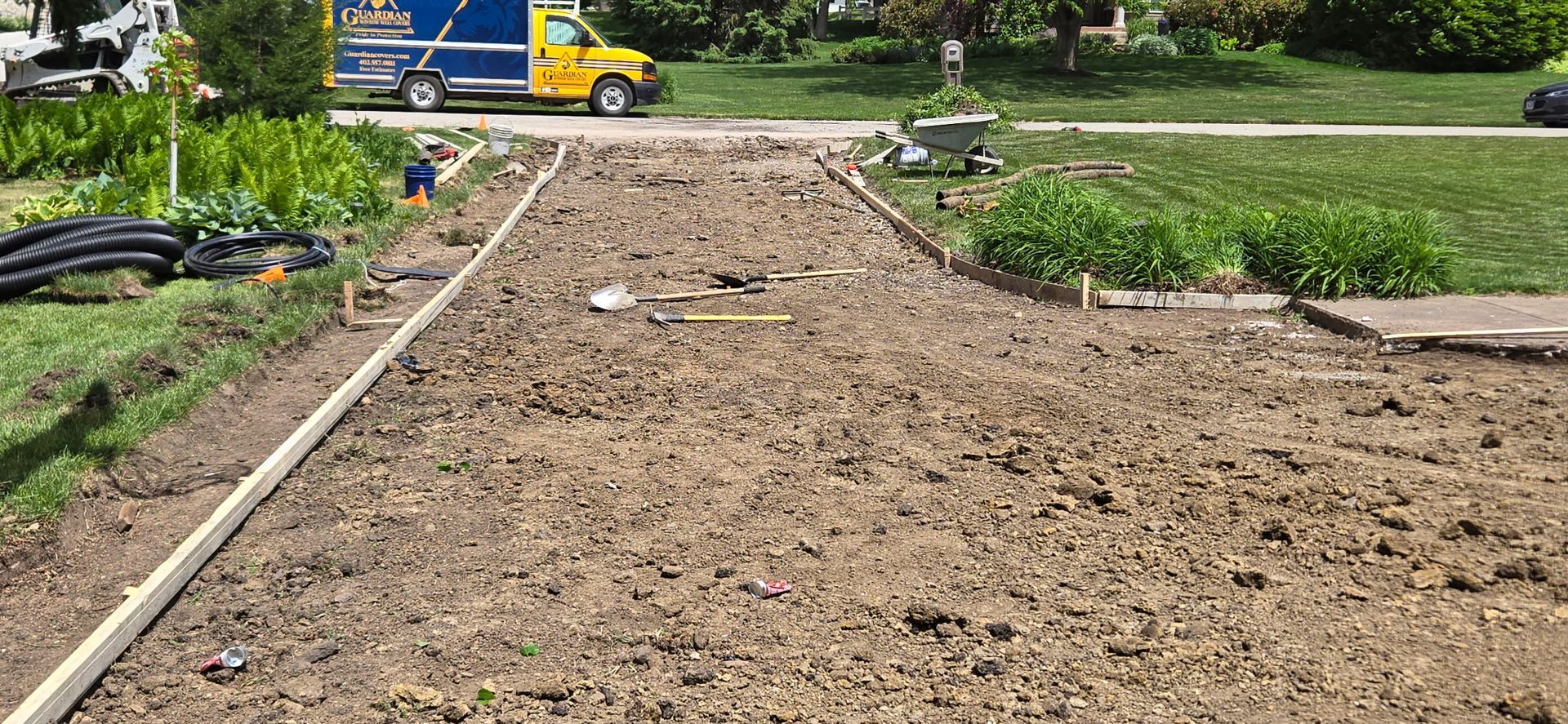 A yellow truck is driving down a dirt road.