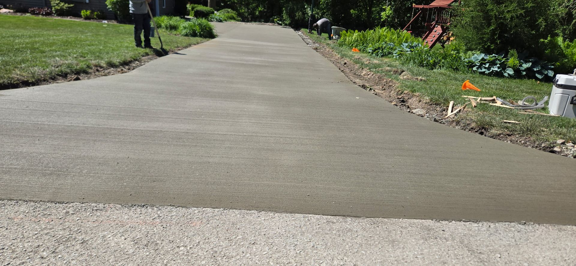 A man is walking down a concrete driveway.