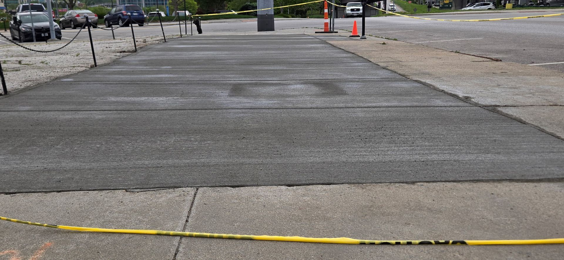 A concrete driveway with a yellow tape on the side of it