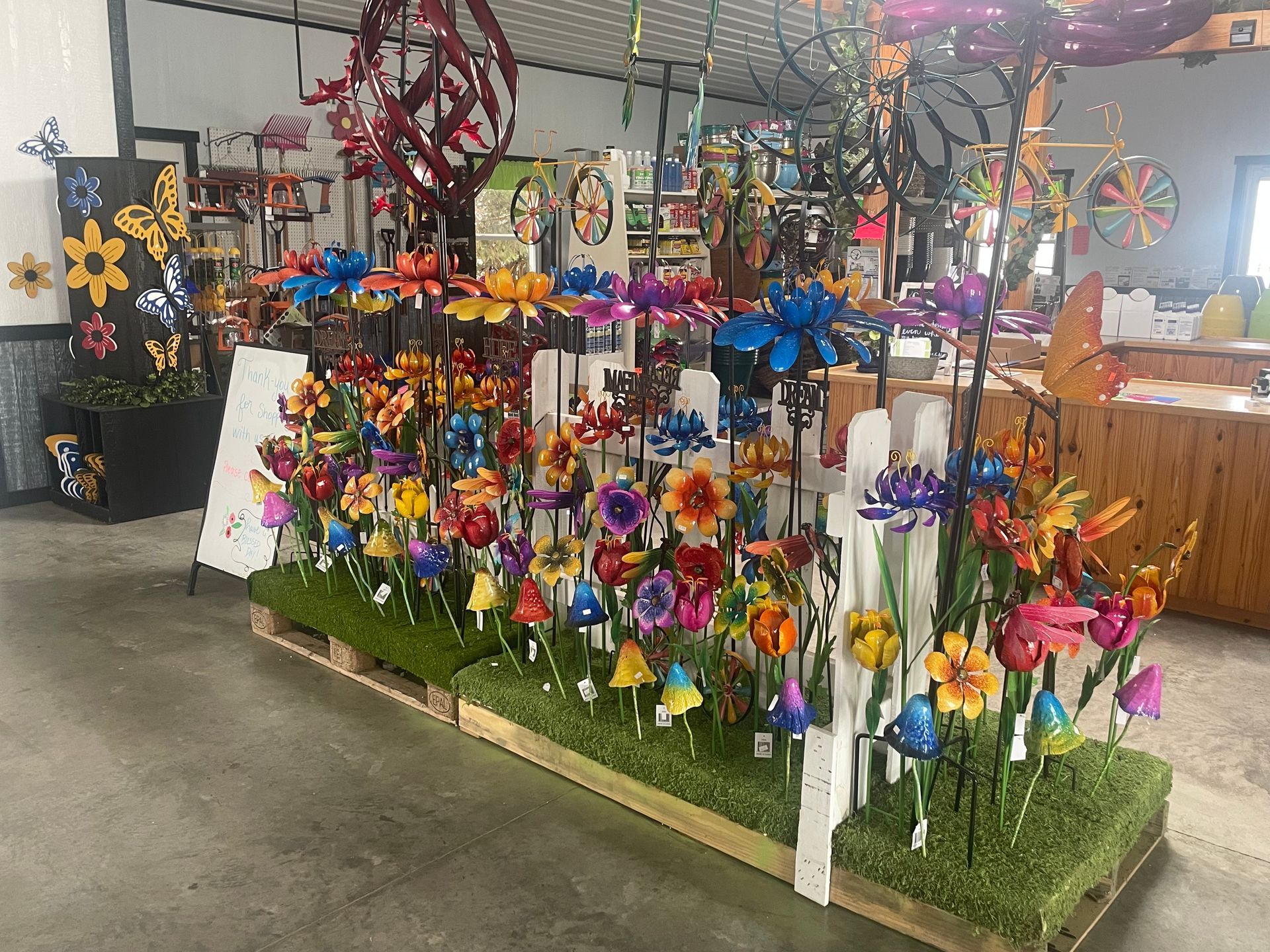 A bunch of colorful flowers are sitting on top of a wooden pallet in a store.