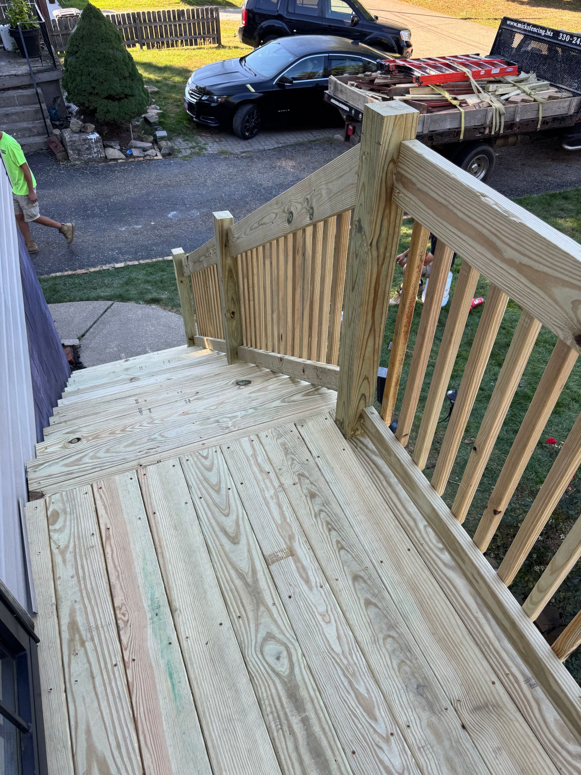 Newly constructed wooden deck with steps and railing.