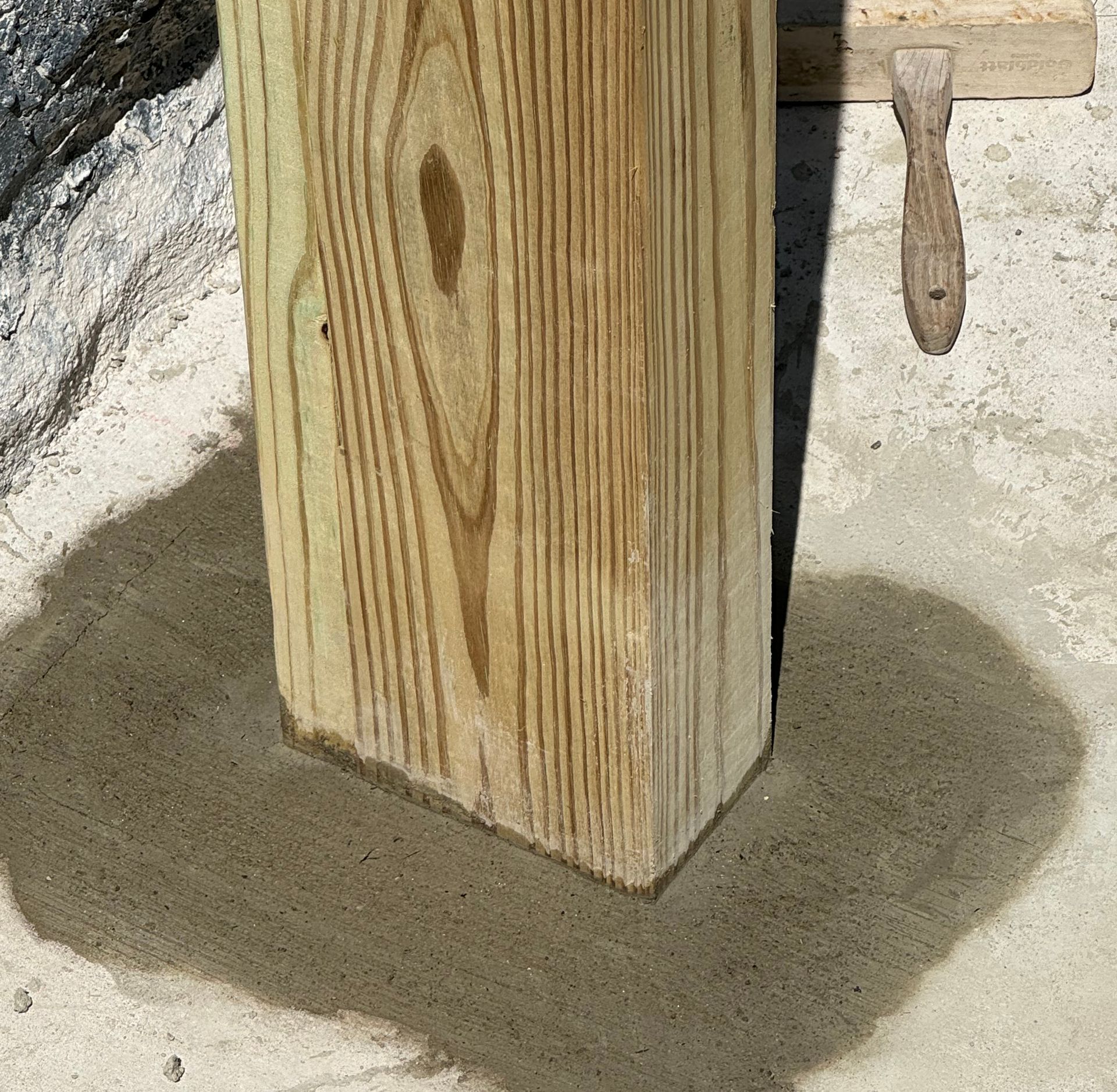 Wooden post set in concrete.