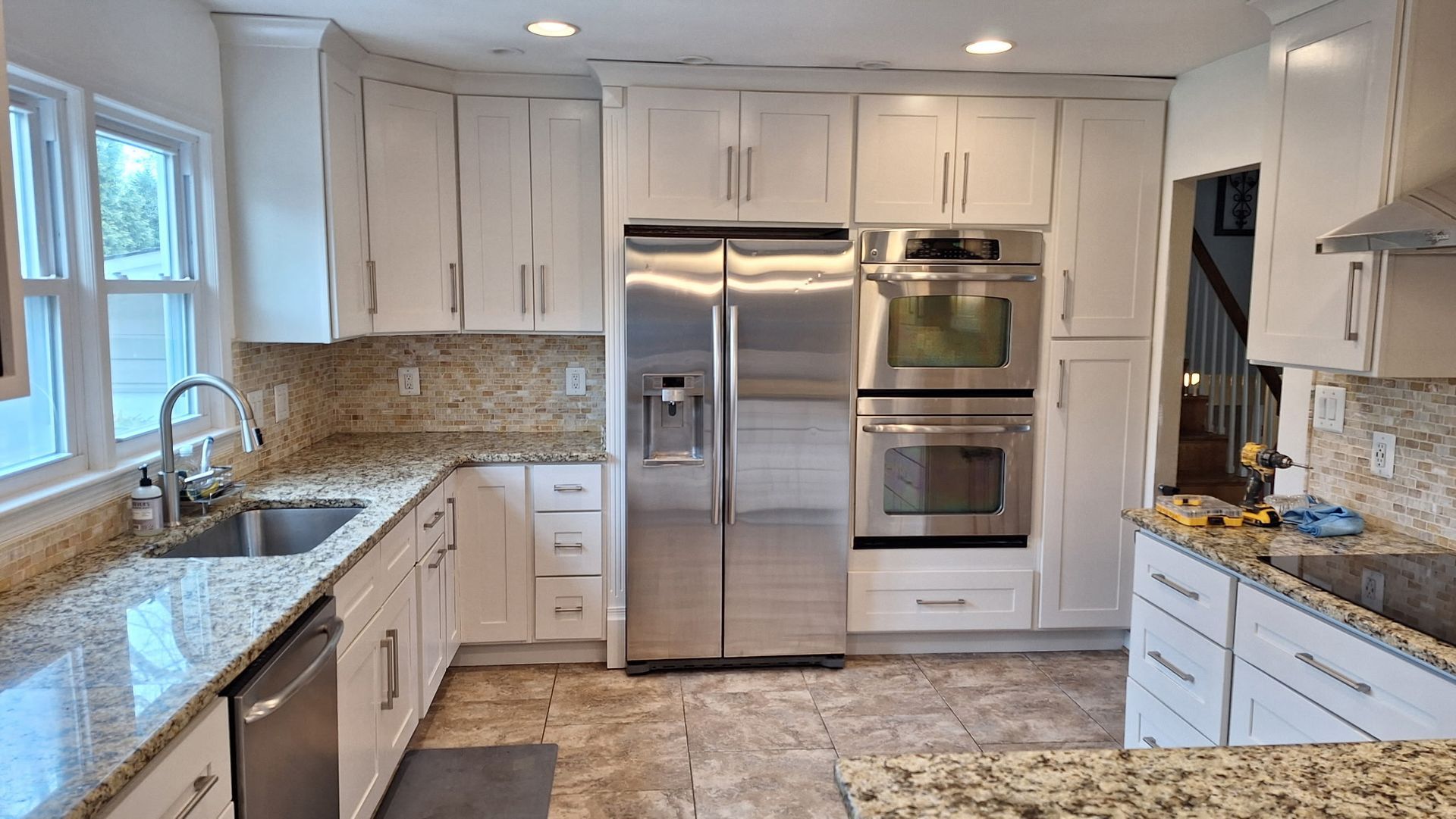 A kitchen with stainless steel appliances and granite counter tops.