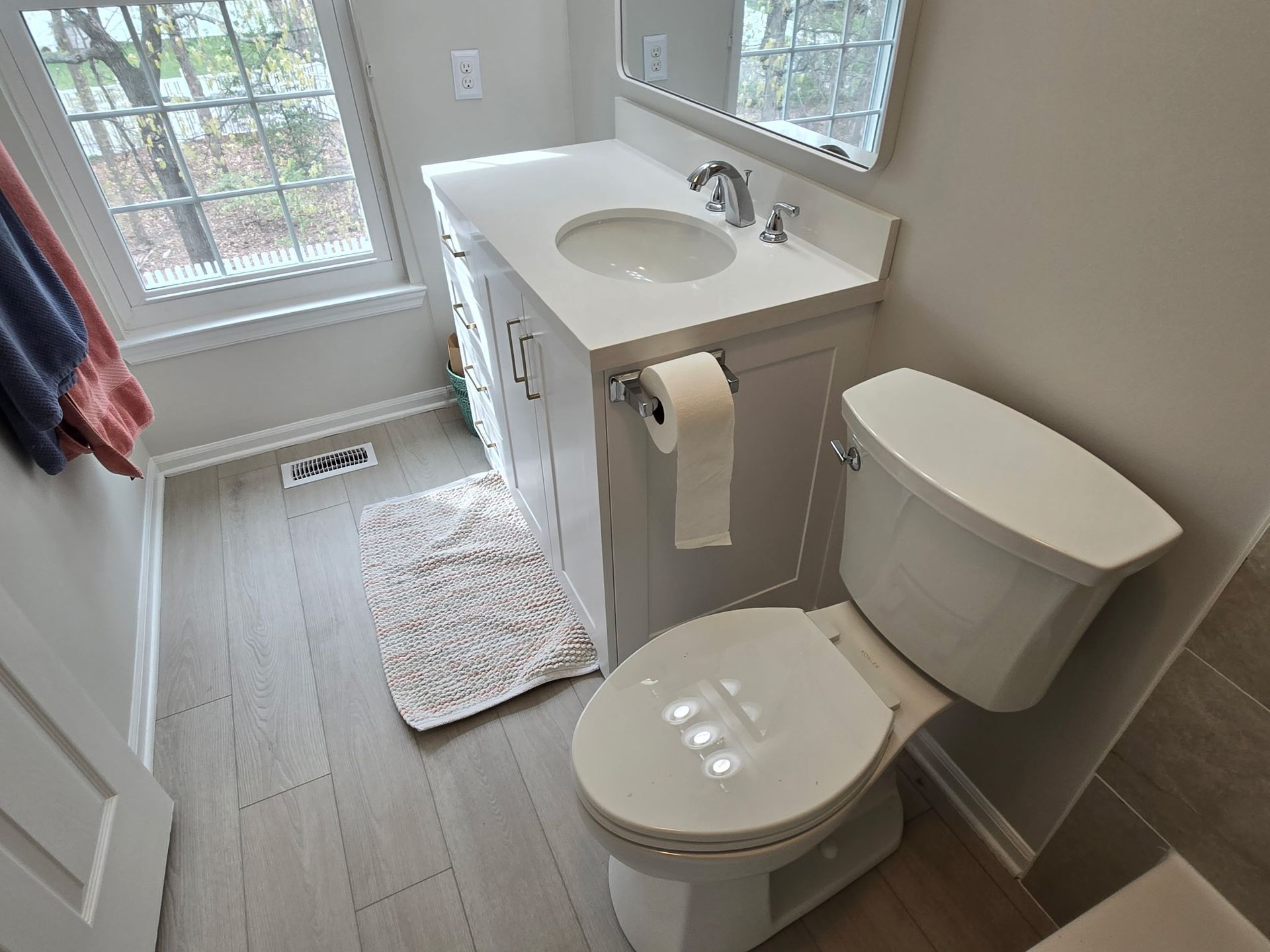 A bathroom with a toilet , sink and mirror