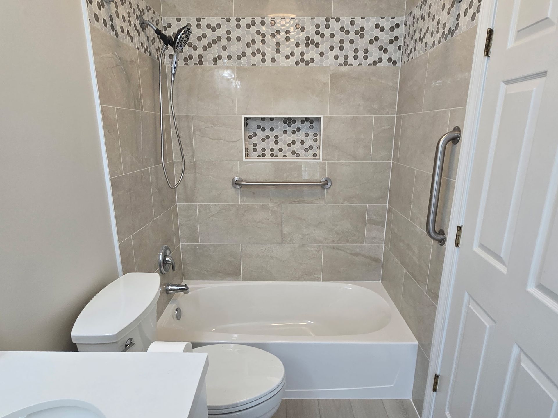 A bathroom with a tub , toilet , sink and shower.