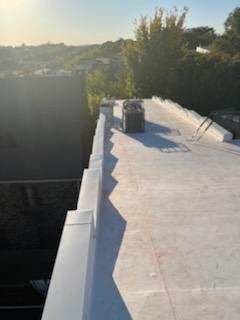 A white roof with a chimney on top of it.