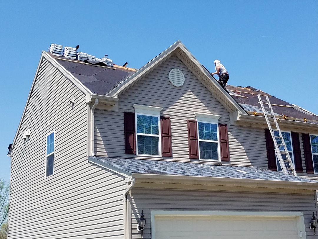 a man is working on the roof of a house