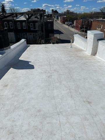 A white roof with a view of a city in the background.