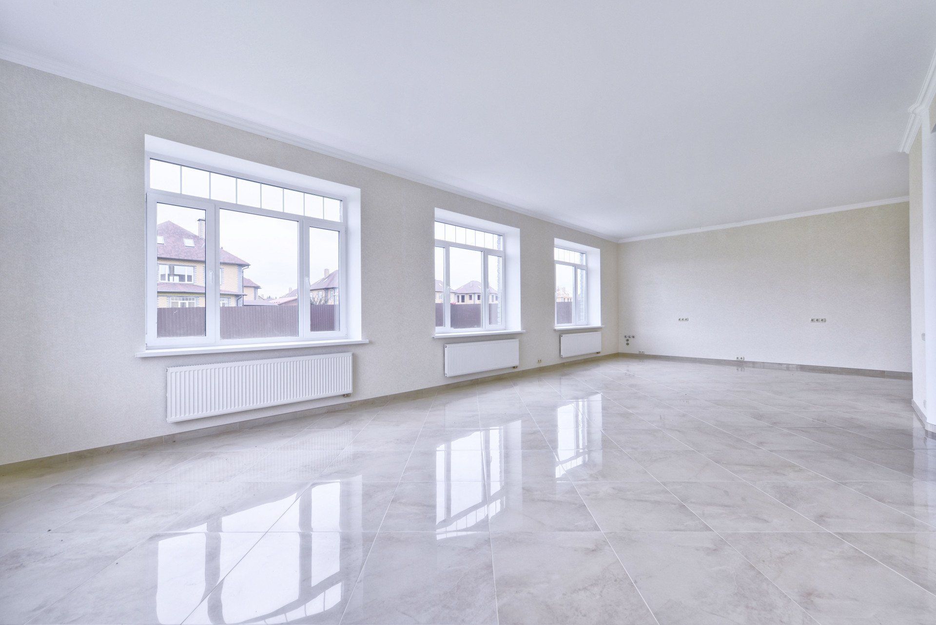 a large empty room with a marble floor and lots of windows