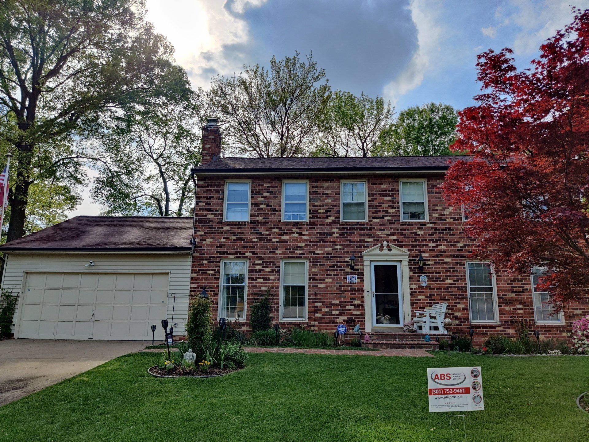 a large brick house with a sign in front of it