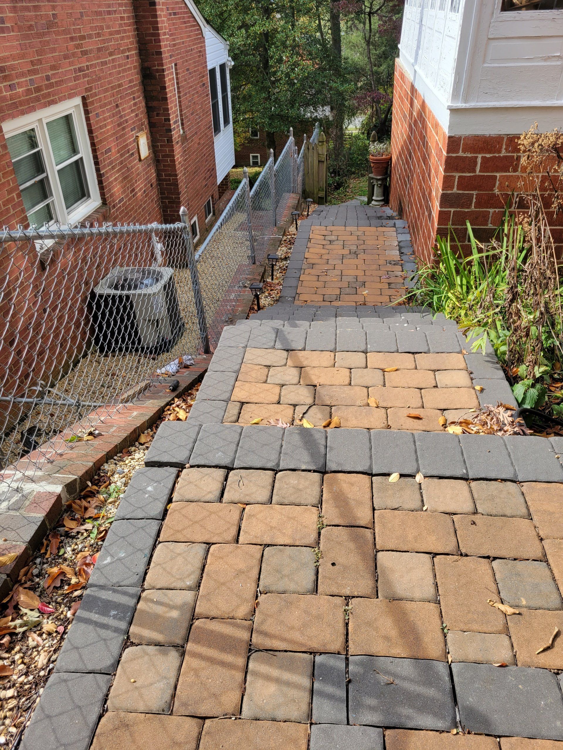 a brick walkway leading up to a brick house