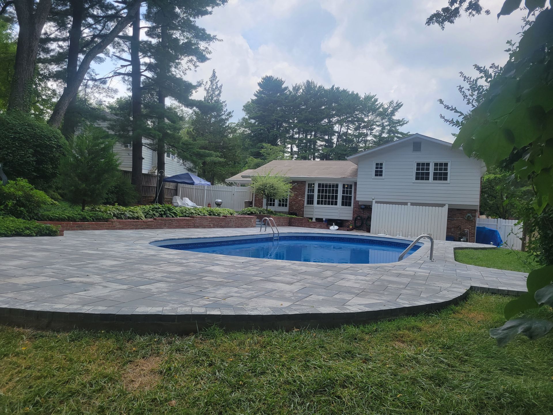 a large swimming pool is in the backyard of a house