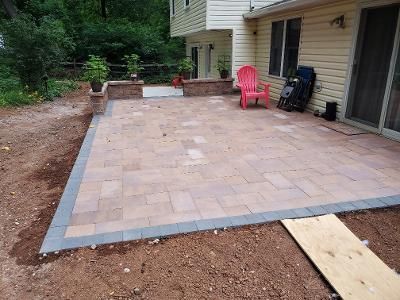a patio with a red chair on it in front of a house