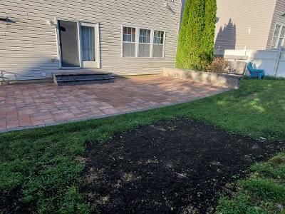 there is a brick patio in the backyard of a house