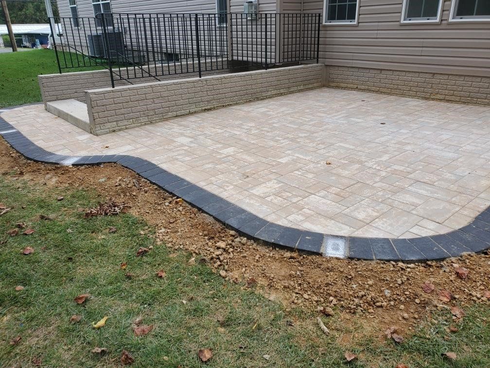 a patio with a railing and stairs in front of a house