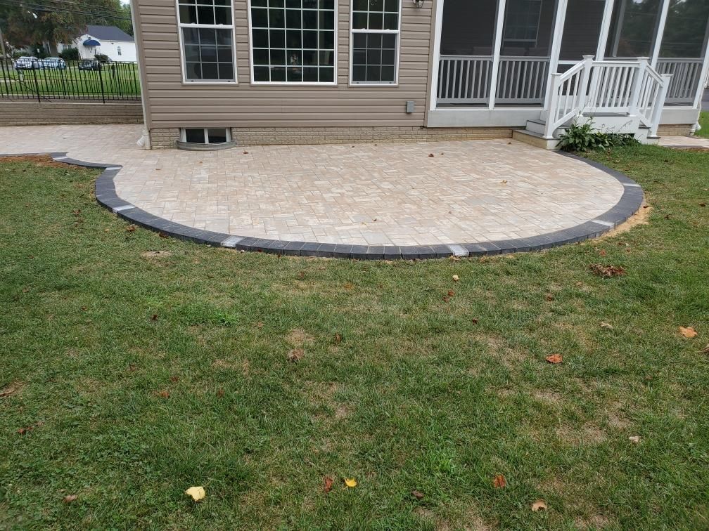 a patio in the backyard of a house with a screened in porch