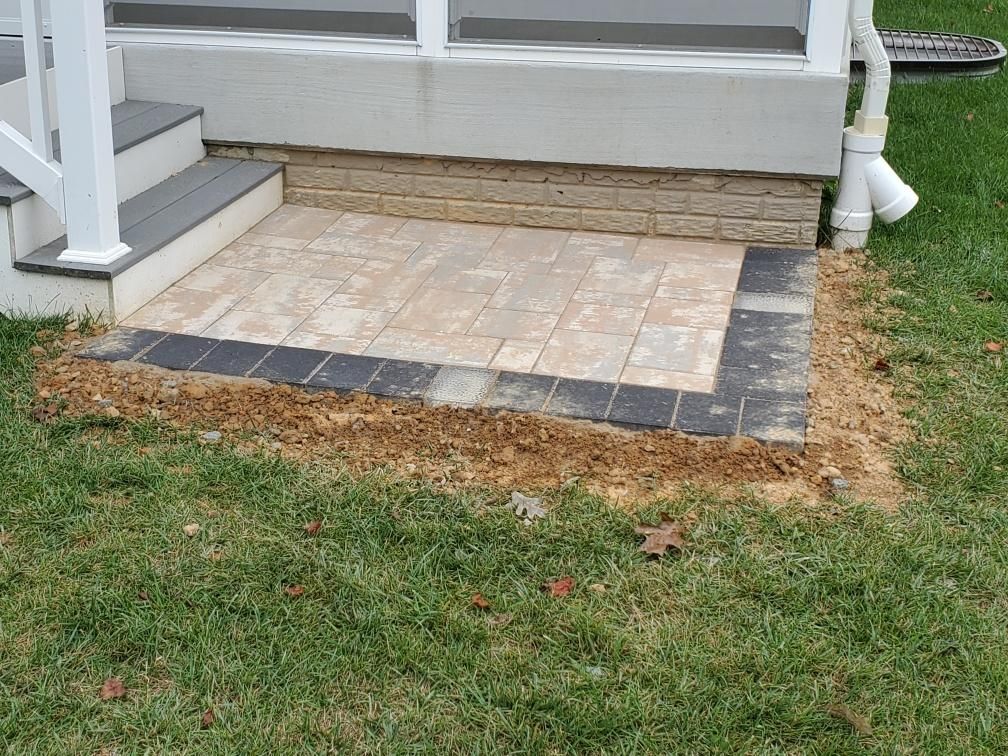 a brick walkway is being built in front of a house