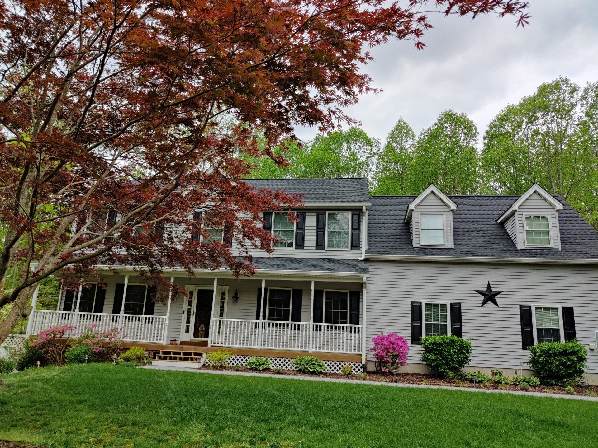 a large white house with a large porch and a star on the roof