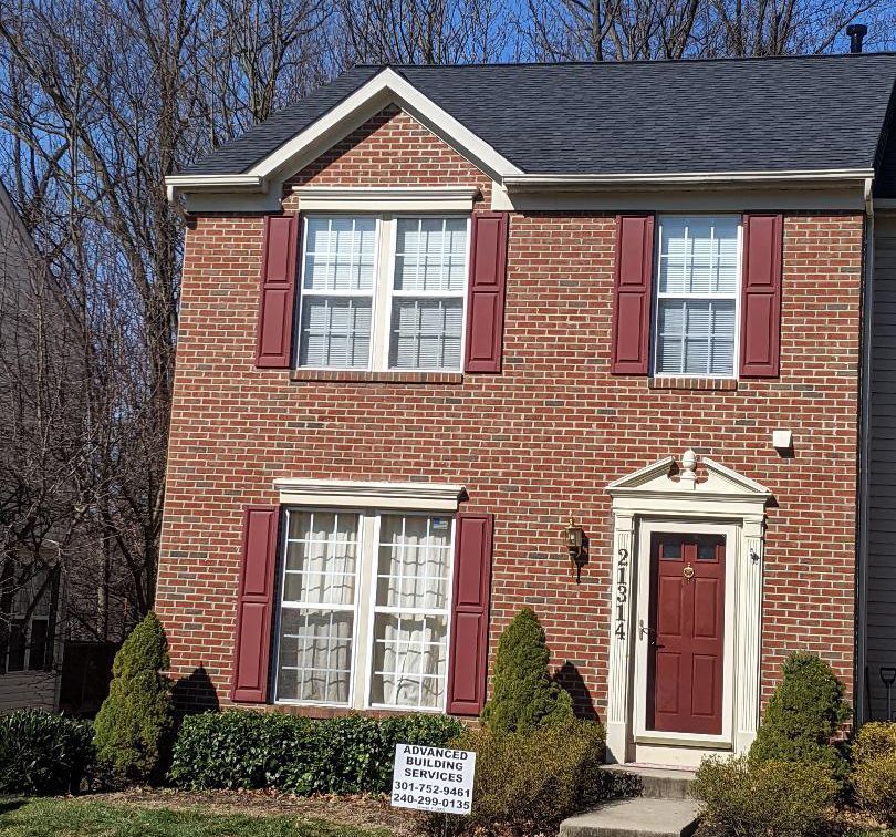 a brick house with red shutters and white trim