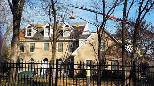 an aerial view of a brick house with a gray roof