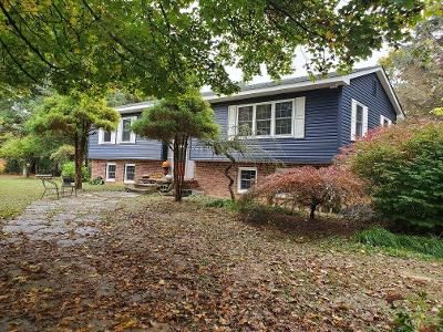 a large house with a blue siding is surrounded by trees and leaves
