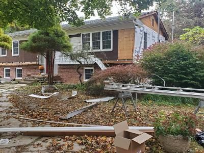 a house is being remodeled with a lot of leaves on the ground