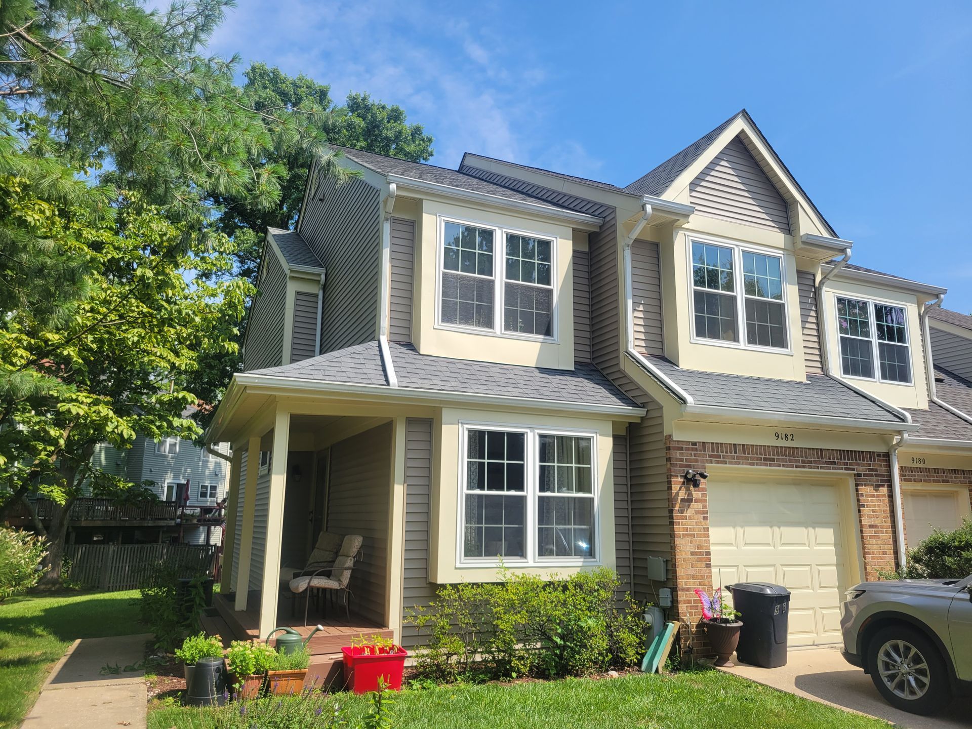 a house with a car parked in front of it on a sunny day