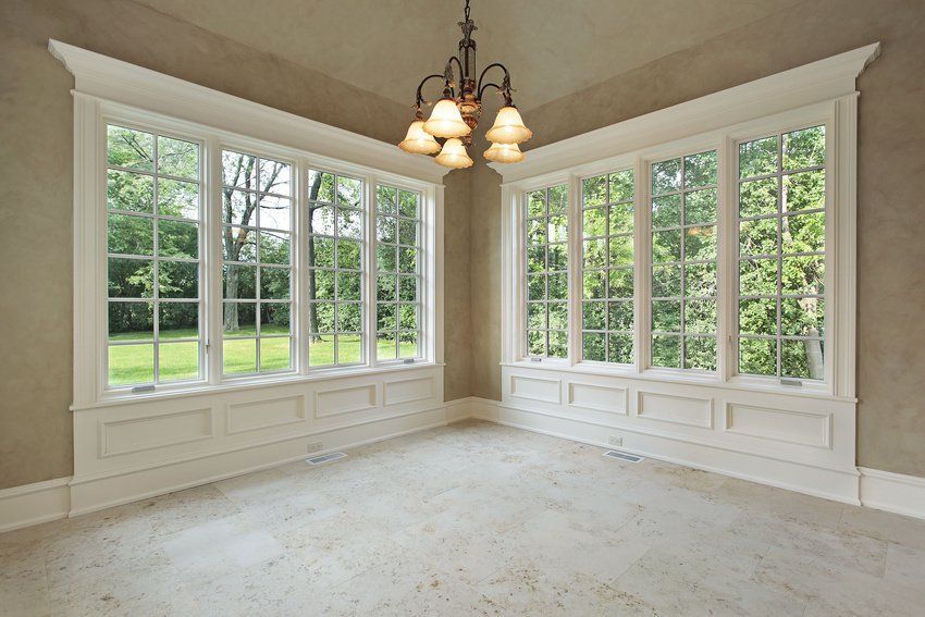 an empty room with lots of windows and a chandelier