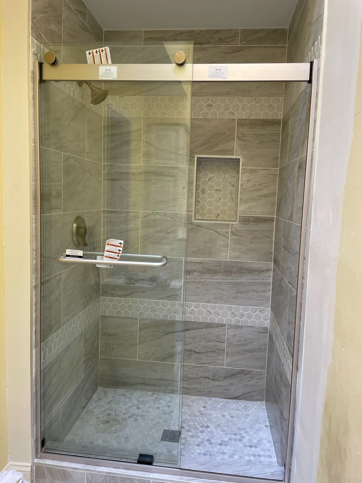A shower stall with a sliding glass door in a bathroom