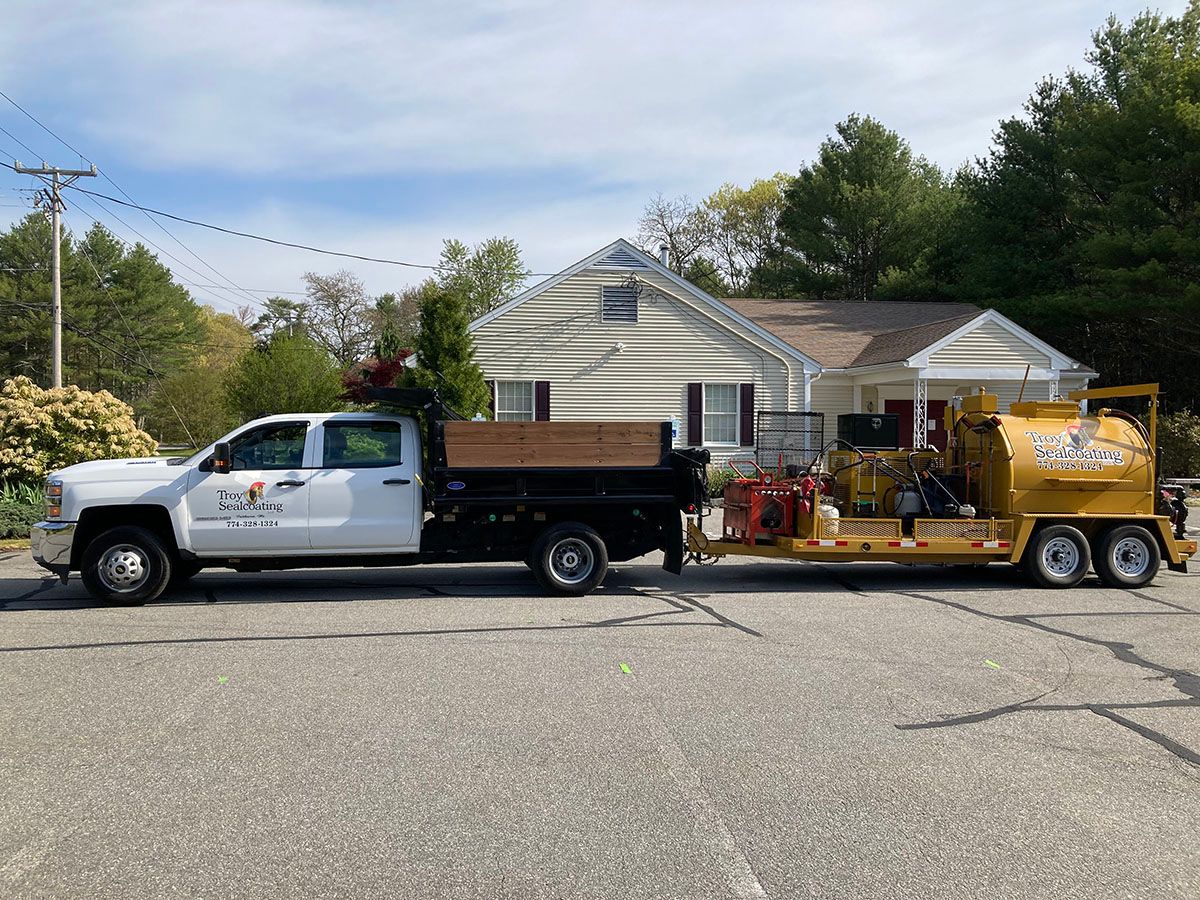 Troy Sealcoating LLC truck parked in front of a house