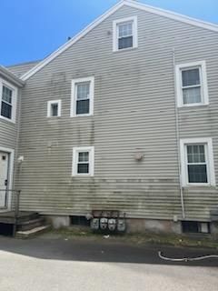 A large house with a lot of windows and a lot of moss on the side of it.
