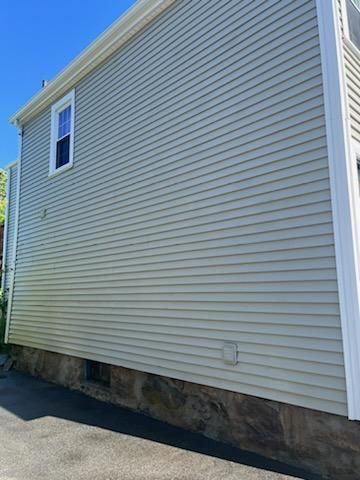 The side of a house with a lot of windows and a blue sky in the background.