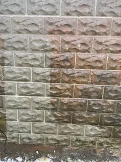 A close up of a brick wall before and after being cleaned.