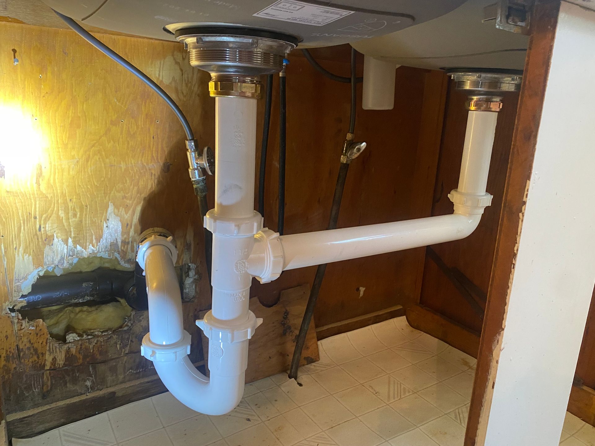 A sink with a plumbing pipe underneath it