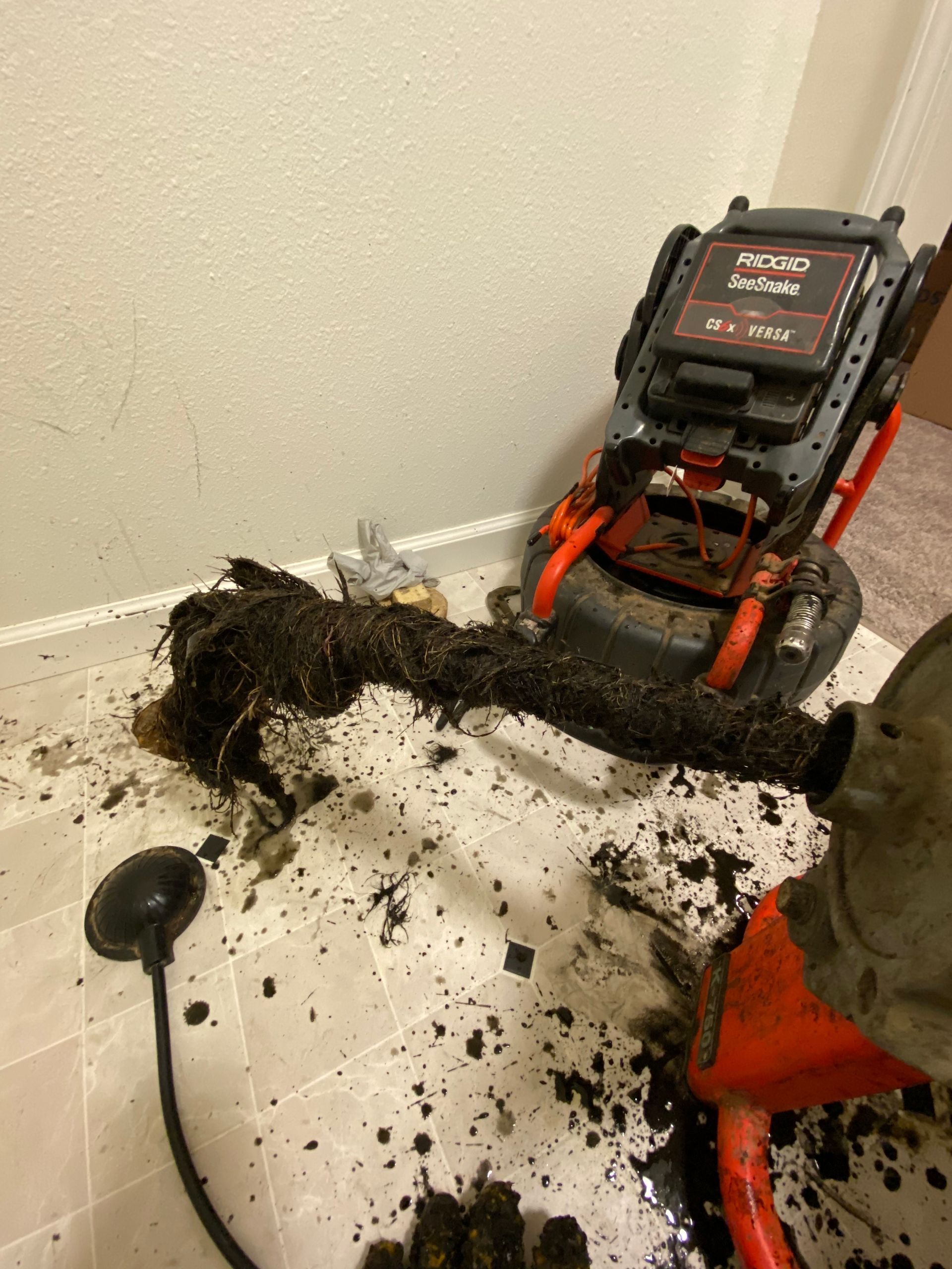 A person is using a camera to remove a drain in a bathroom.