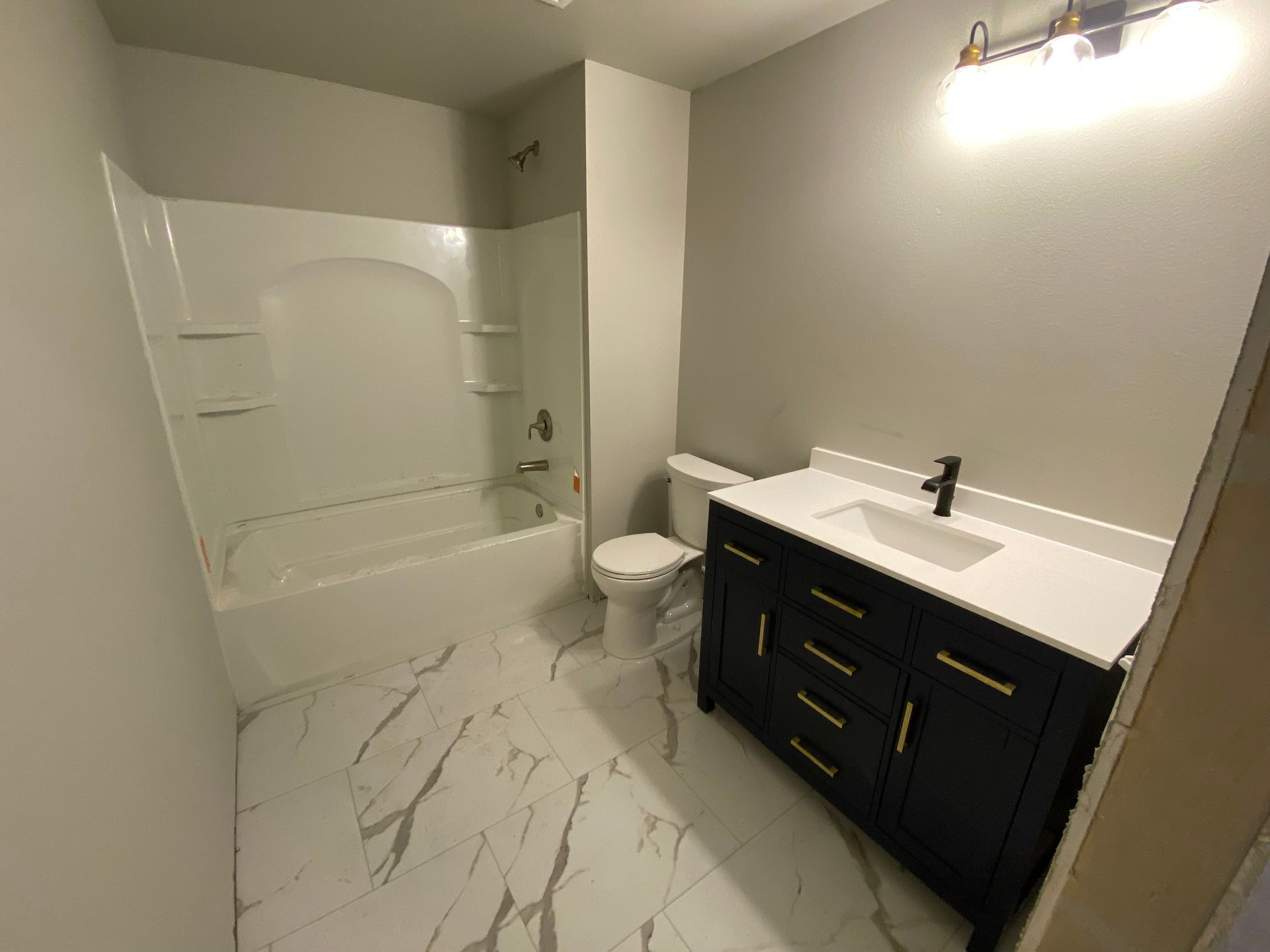 White bathroom with a sink, toilet, bathtub, and shower.