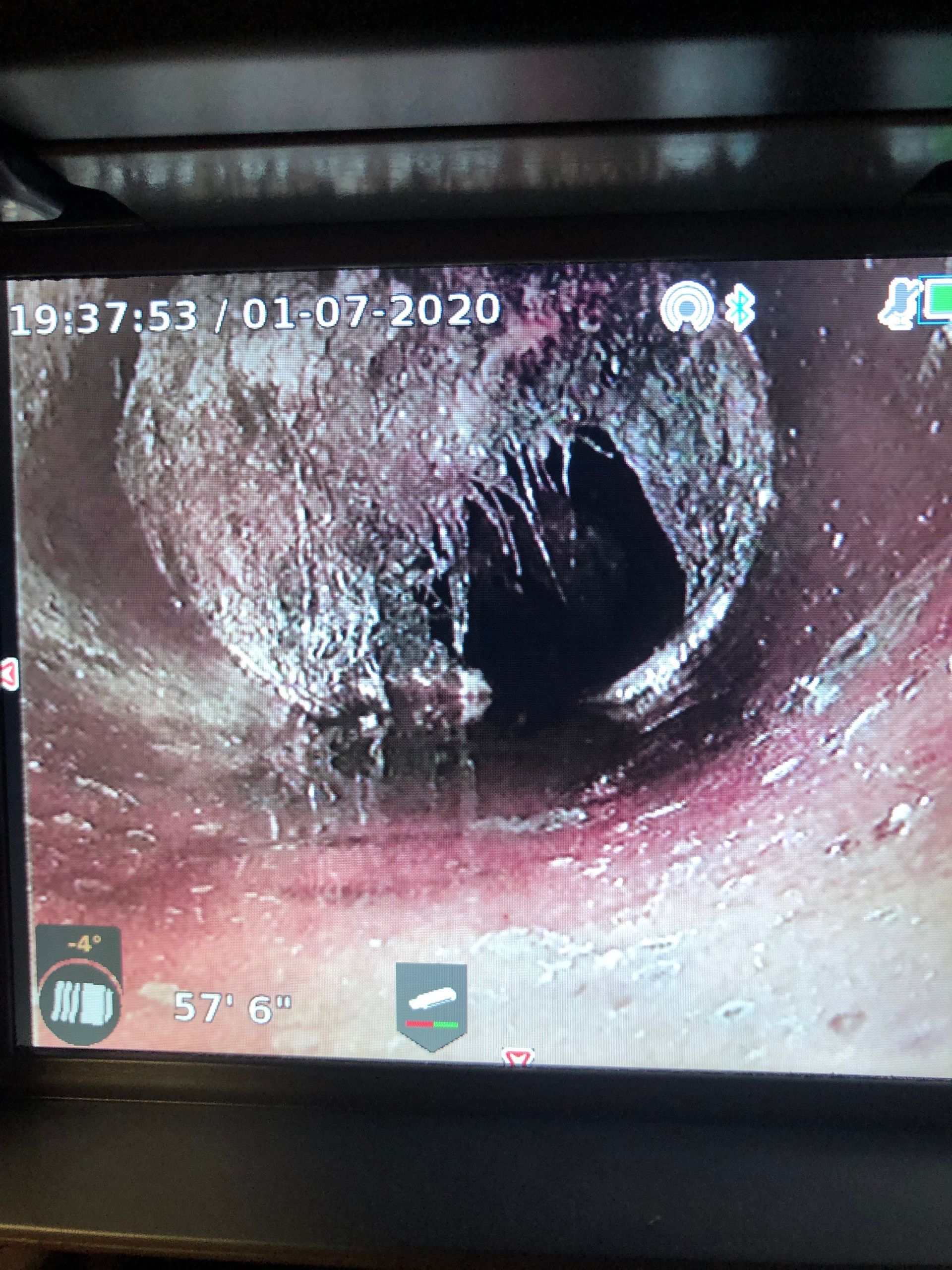 A camera is taking a picture of a hole in a pipe.