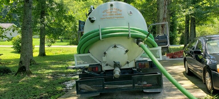 septic truck with hose parked with hose attached pumping and inspections