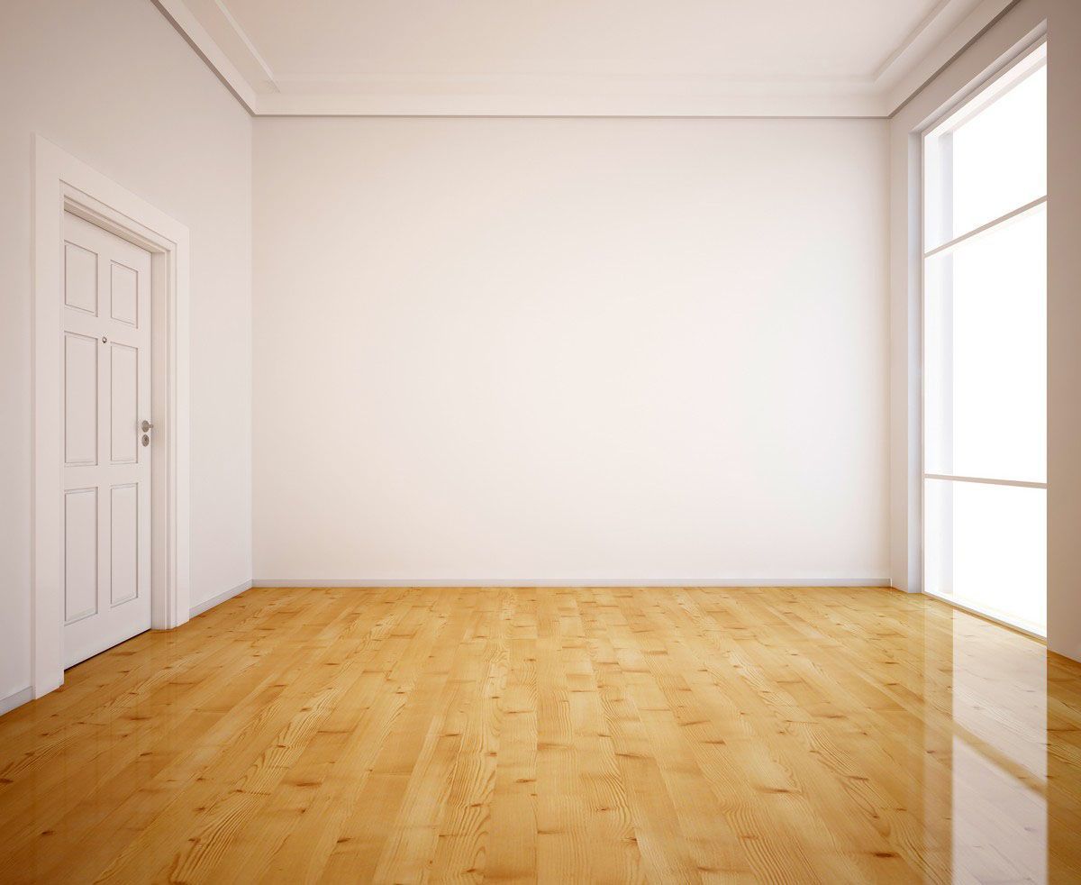 Empty room with white walls, wooden floor, door, and large window.